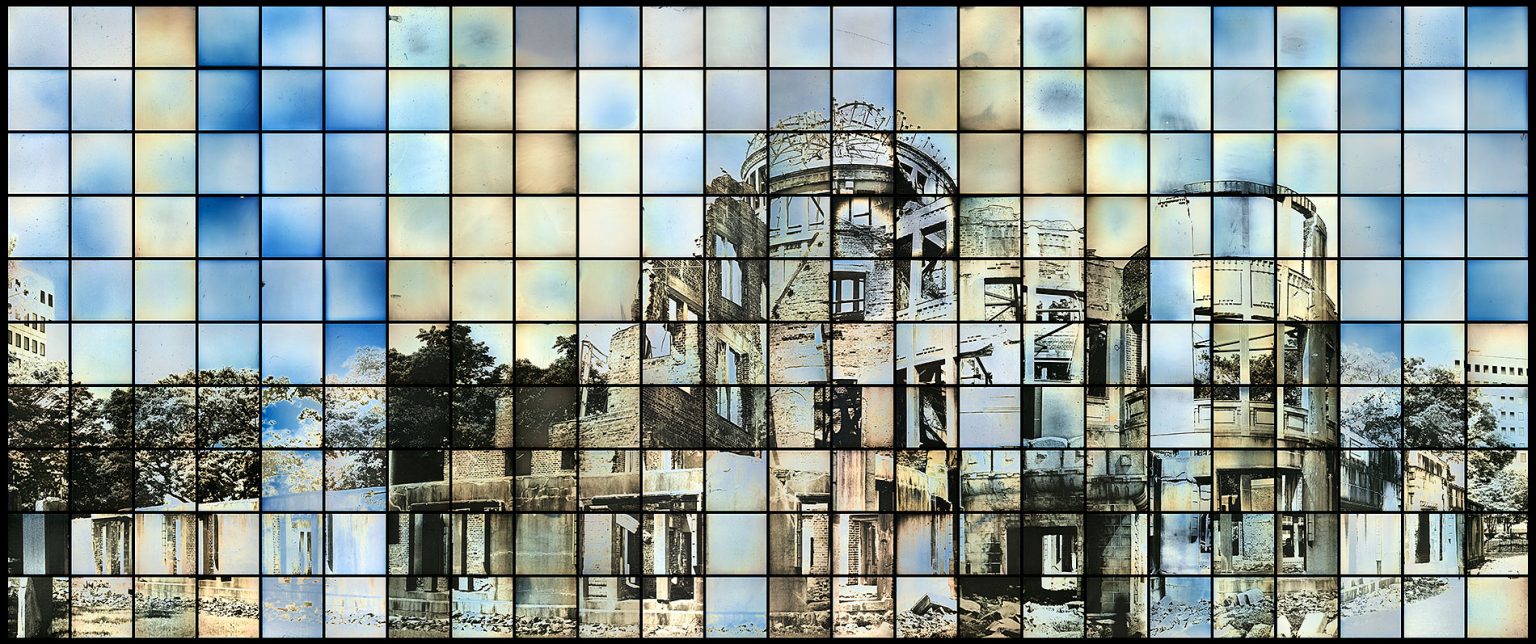 Ein Fotomosaik aus kleinen farbigen Tafeln bildet das Bild des Hiroshima-Friedensmahnmals, auch bekannt als Atombombenkuppel, vor einem hellblauen Hintergrund. (KI generierte Beschreibung)