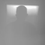 Silhouette einer Person vor einem weichen, hellen Hintergrund mit Farbverlauf. (KI generierte Beschreibung)