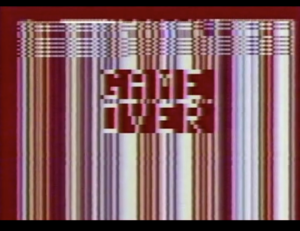 Fehlerhafte Grafik mit vertikalen, mehrfarbigen Linien und verzerrtem „Game Over“-Text in Weiß und Rot, was an einen Fehlerbildschirm eines Digital- oder Videospiels erinnert.