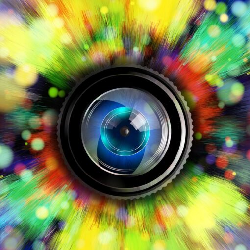 Eine Kameralinse steht in der Mitte eines lebhaften, farbenfrohen Lichtblitzes und eines Bokehs, wodurch ein Effekt entsteht, der an ein Auge erinnert. (KI generierte Beschreibung)