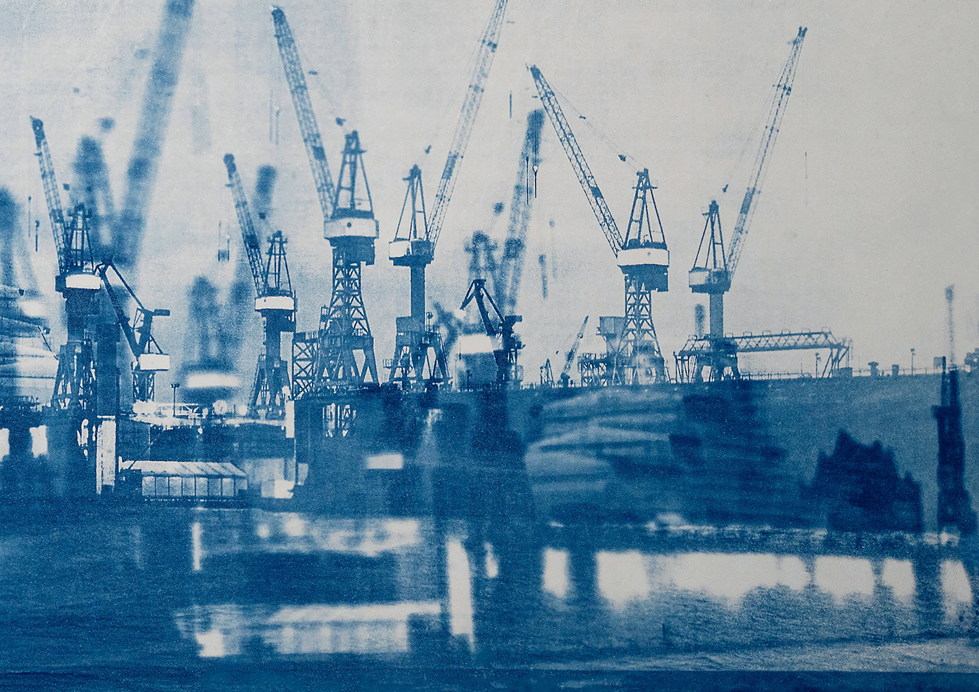 Ein blau getöntes, künstlerisches Bild einer Werft mit mehreren Kränen und industriellen Strukturen, die sich im Wasser spiegeln. (KI generierte Beschreibung)